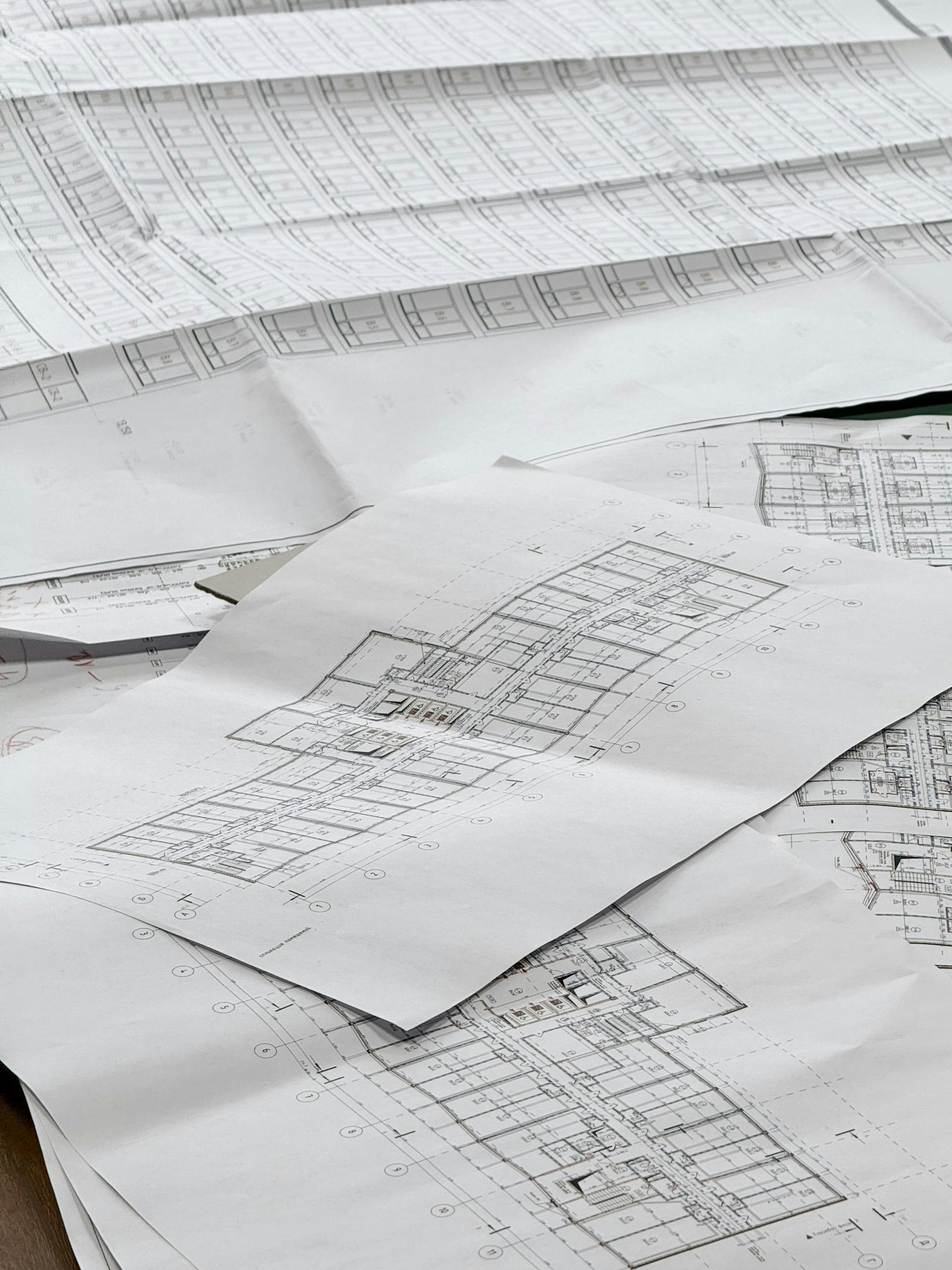 Close-up of detailed architectural blueprints spread out on a desk.
